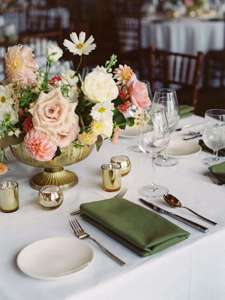 Elegant table setting featuring blush flowers and green napkins, showcasing wedding decor at Edgewood Tahoe Resort.