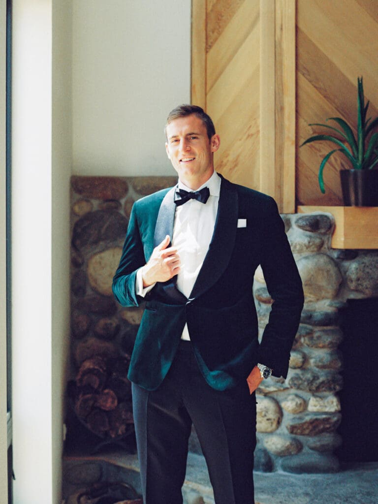 The groom, dressed in a tuxedo, poses for a photo at Gar Woods Lake Tahoe Wedding, capturing a moment of celebration.