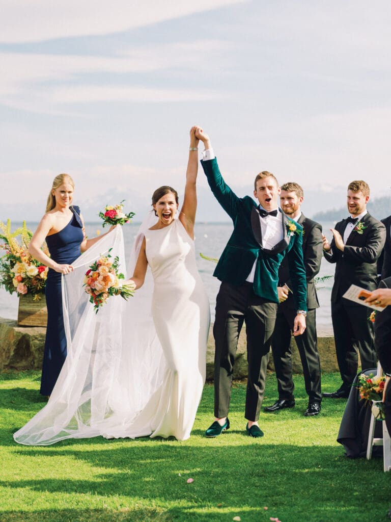 Just married bride and groom on a picturesque beach at their Gar Woods Lake Tahoe wedding.