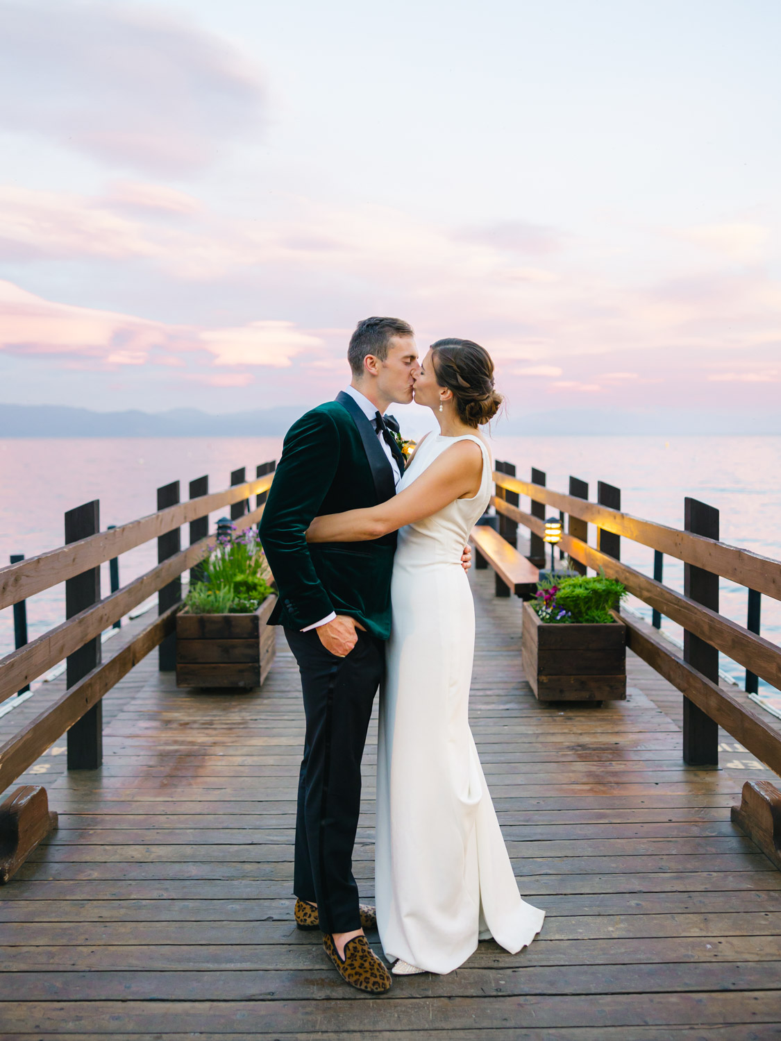 A bride and groom share a kiss on a picturesque pier at their Gar Woods Lake Tahoe wedding.