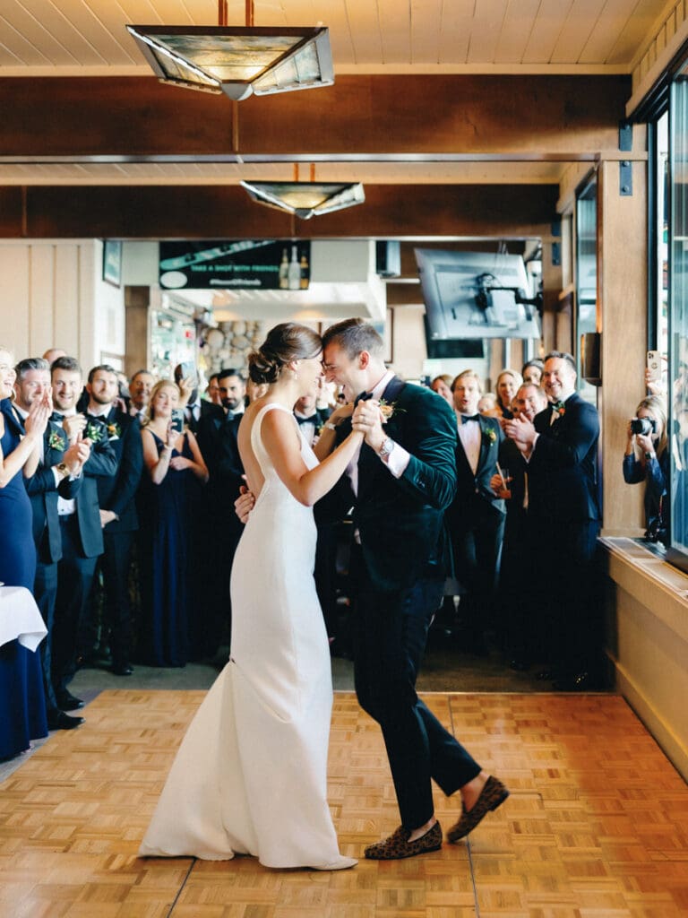 A bride and groom share their first dance at their wedding reception at Gar Woods, Lake Tahoe, surrounded by love and joy.