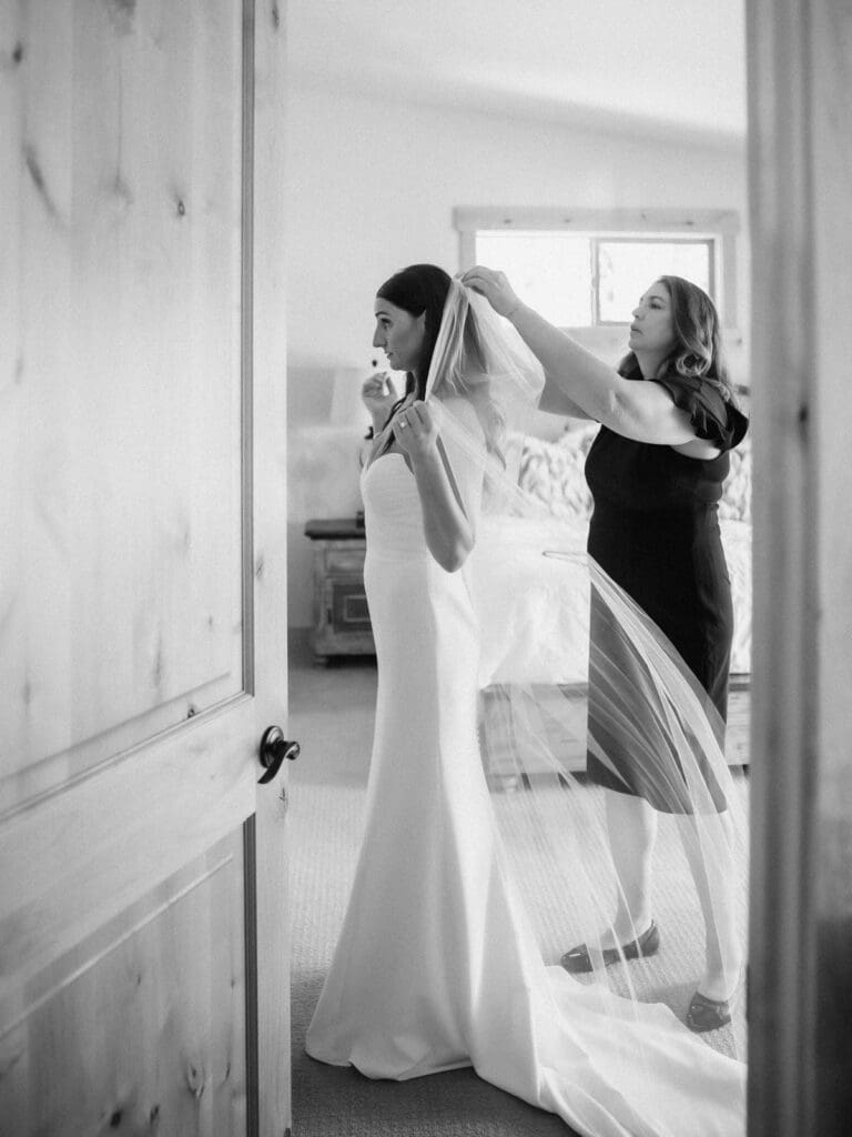 A joyful mother and bride in her wedding attire, getting ready in Lake Tahoe home, filled with excitement and elegance. 