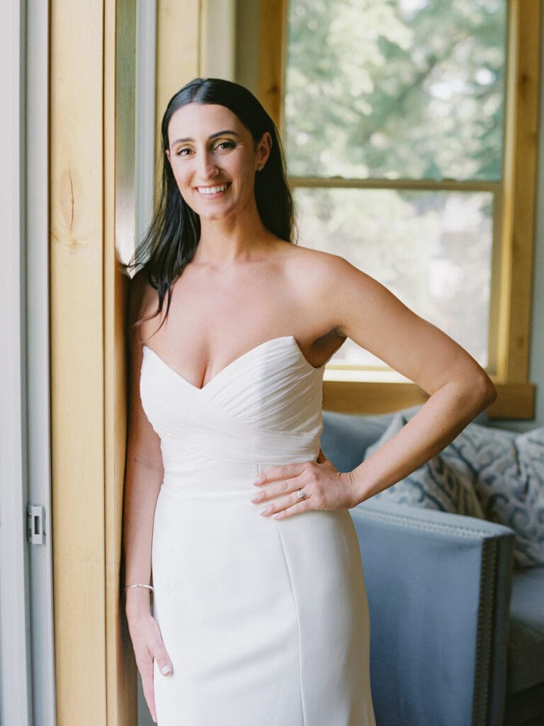 A joyful bride in her wedding attire, getting ready in Lake Tahoe cabin, filled with excitement and elegance. 