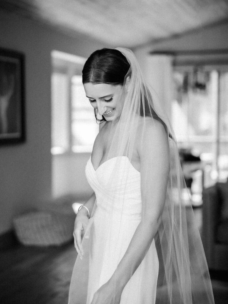 A beautiful bride in a white gown and veil poses gracefully at Gar Woods, Lake Tahoe, radiating joy.