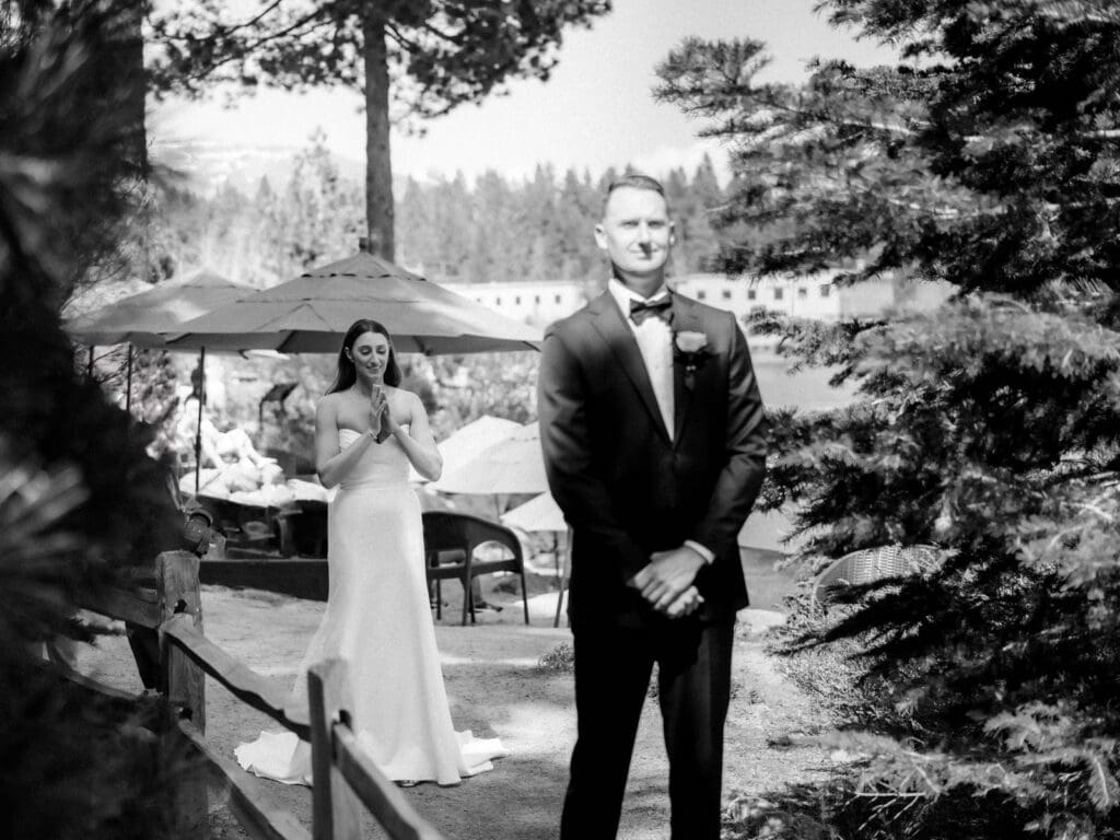 A bride and groom share a heartfelt first look in front of Gar Woods Grill & Pier wedding venue in Lake Tahoe.