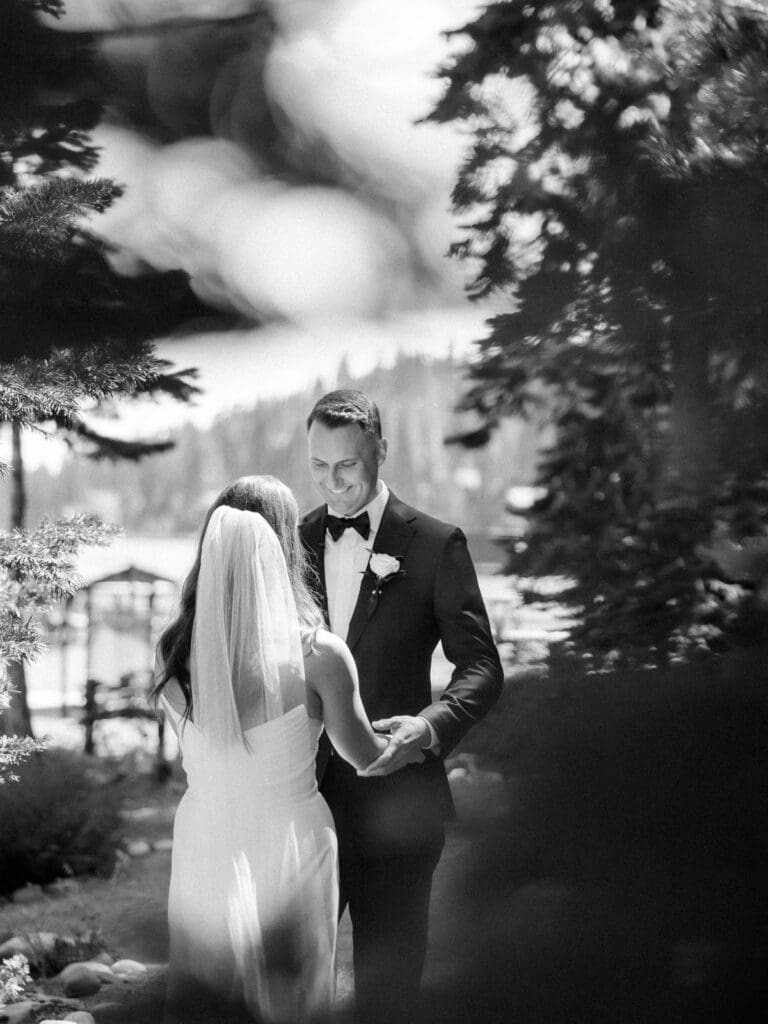 A bride and groom share a heartfelt first look in front of Gar Woods Grill & Pier wedding venue in Lake Tahoe.