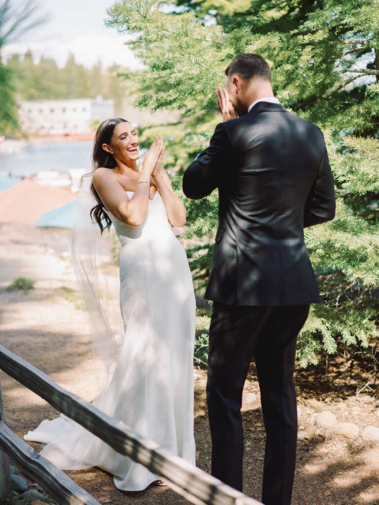 A bride and groom share a heartfelt first look in front of Gar Woods Grill & Pier wedding venue in Lake Tahoe.