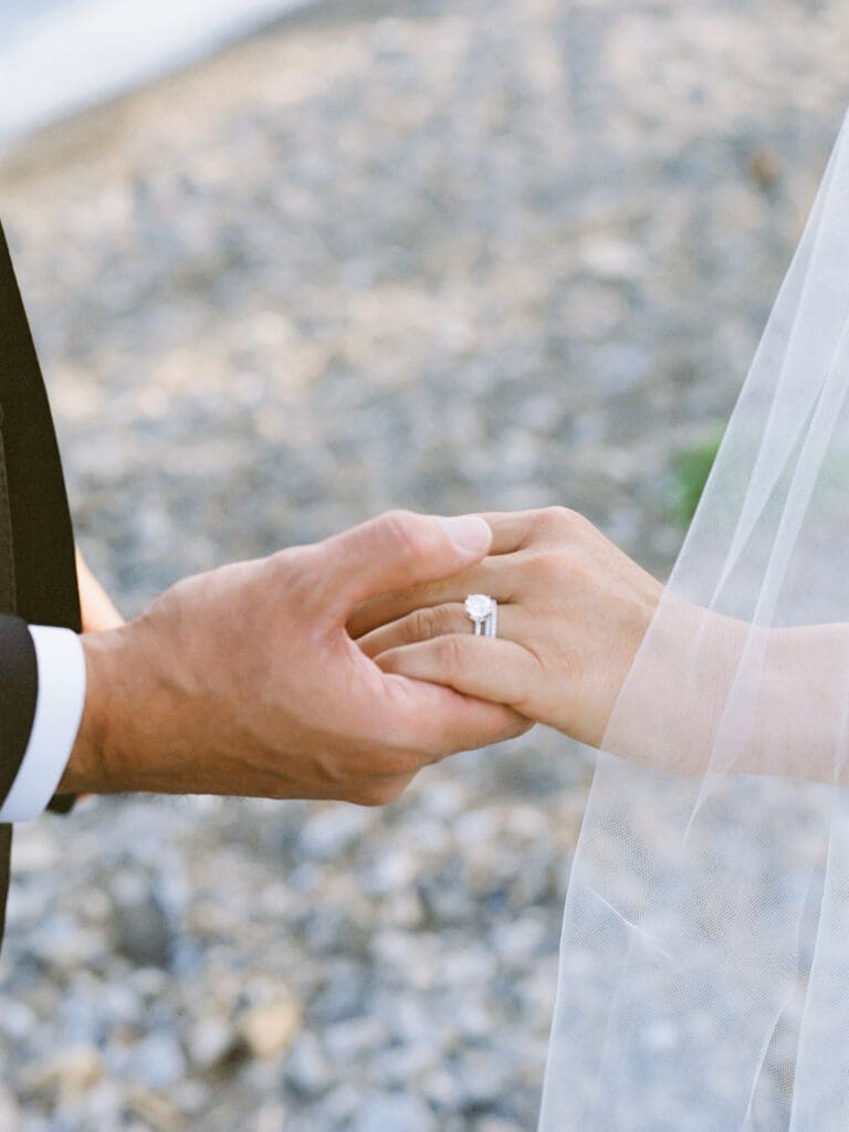 Captivating bride and groom holding hands at Gar Woods, Lake Tahoe, highlighting their love against a breathtaking lakeside backdrop.