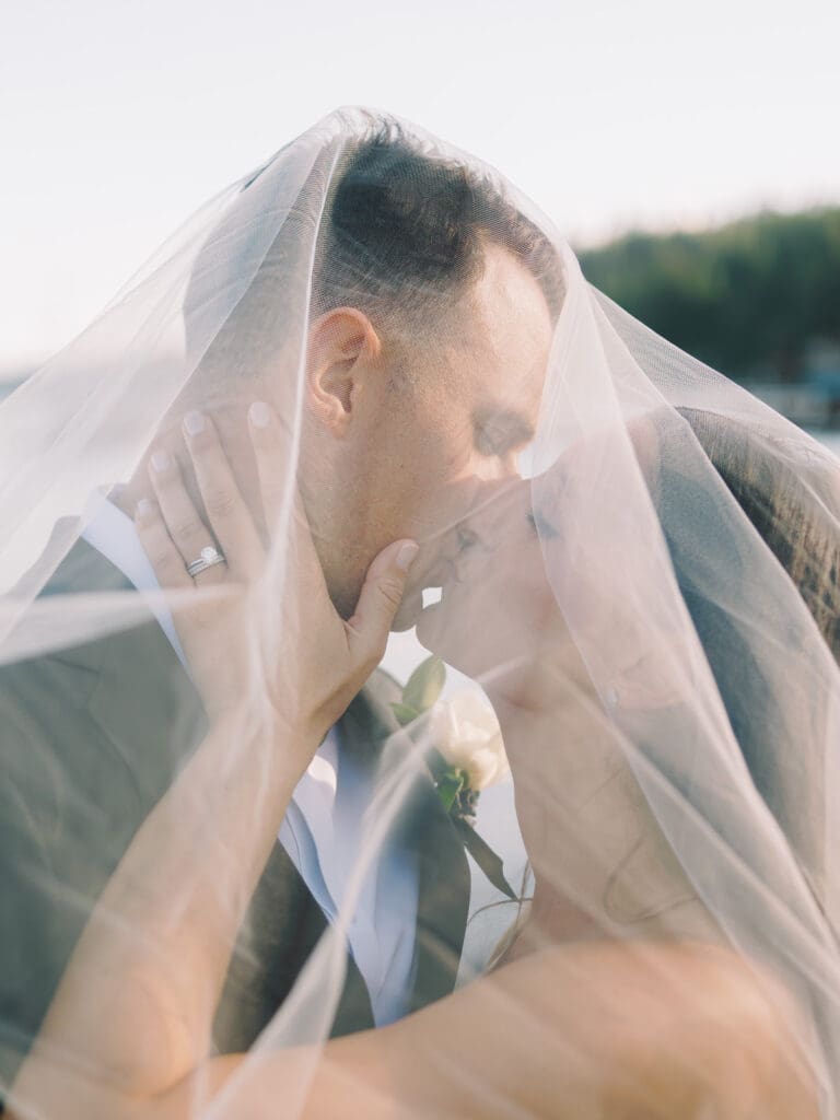 Captivating bride and groom kiss at Gar Woods, Lake Tahoe, highlighting their love against a breathtaking lakeside backdrop.