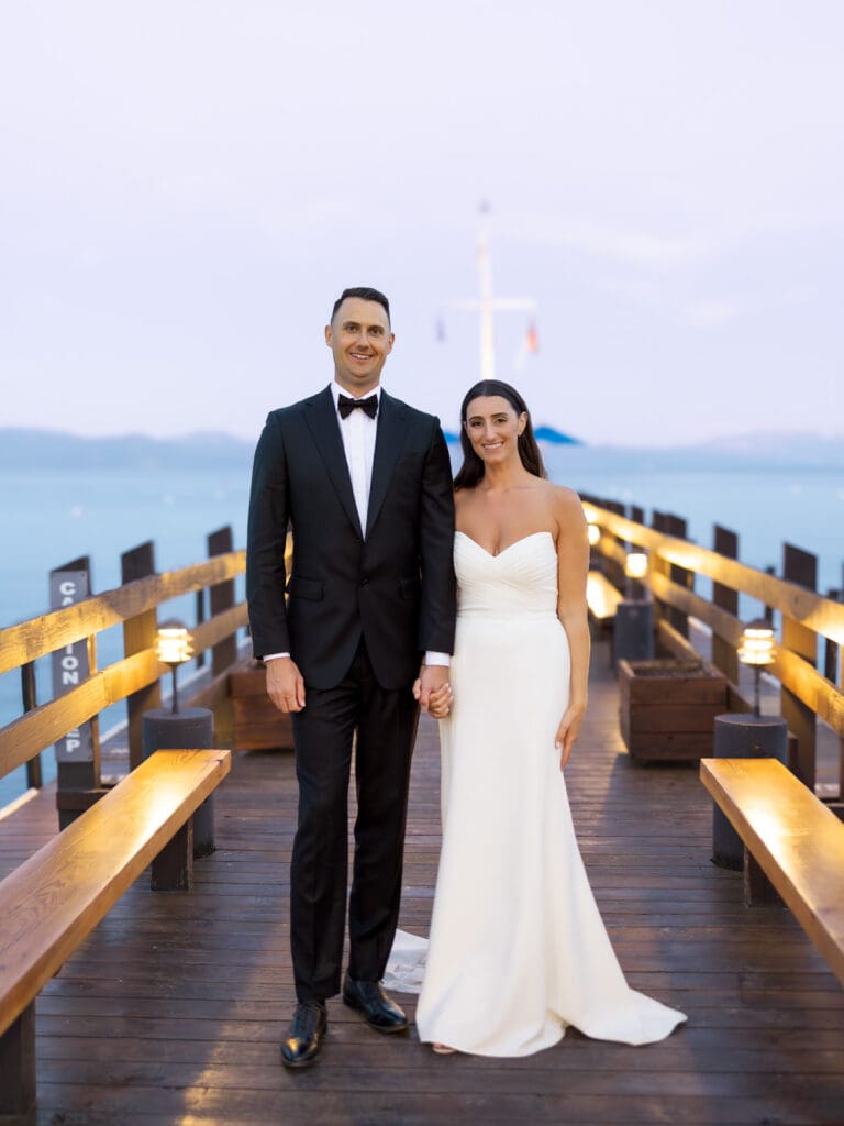 At sunset, a bride and groom pose on the dock, celebrating their love during a beautiful Gar Woods Lake Tahoe wedding.