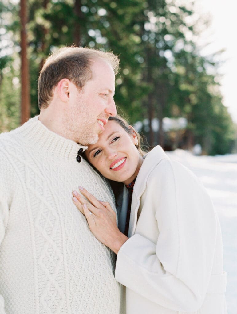 A photo of a couple cuddling and smiling at Lake Tahoe Winter Engagement Shoot