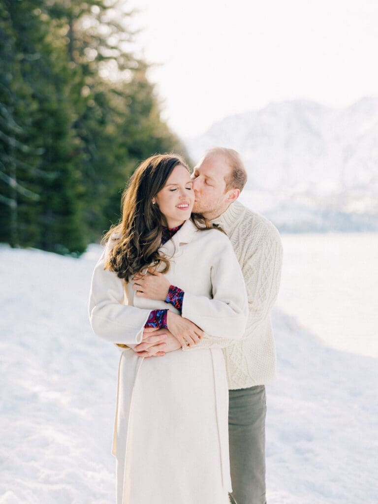 A photo of a couple on the dock cuddling at Lake Tahoe Winter Engagement Shoot