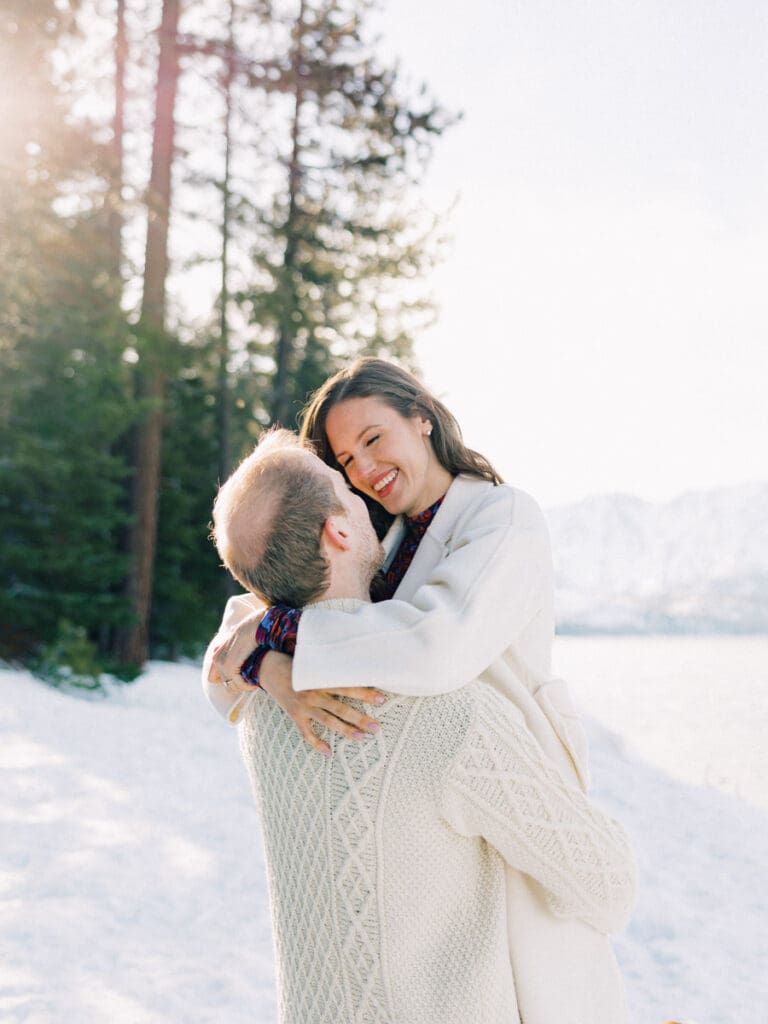 A photo of a couple on cuddling and smiling at each other during Lake Tahoe Winter Engagement Shoot