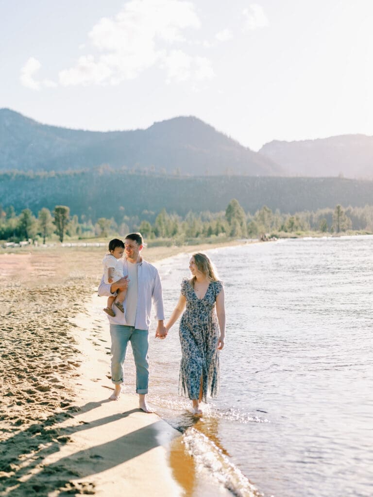 A family walking down the beach and poses for a photo at Lake Tahoe, celebrating their bond in a serene and picturesque lakeside setting.