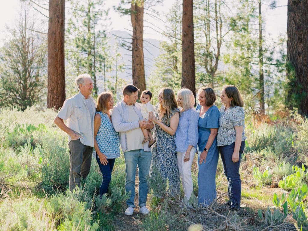 A big family poses for a photo at Lake Tahoe, celebrating their bond in a serene and picturesque lakeside setting.