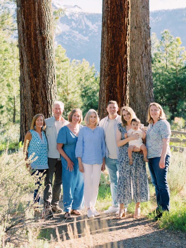 A big family poses for a photo at Lake Tahoe, celebrating their bond in a serene and picturesque lakeside setting.