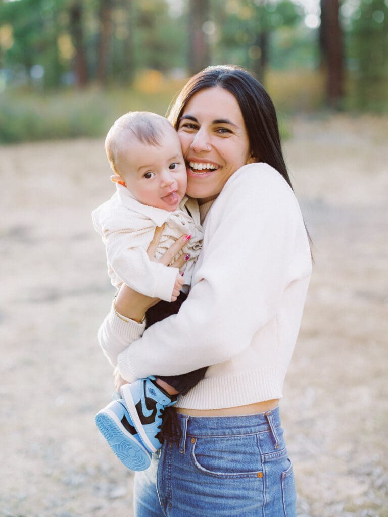 Mother and son poses together in a lush field surrounded by trees during their Lake Tahoe photo session.