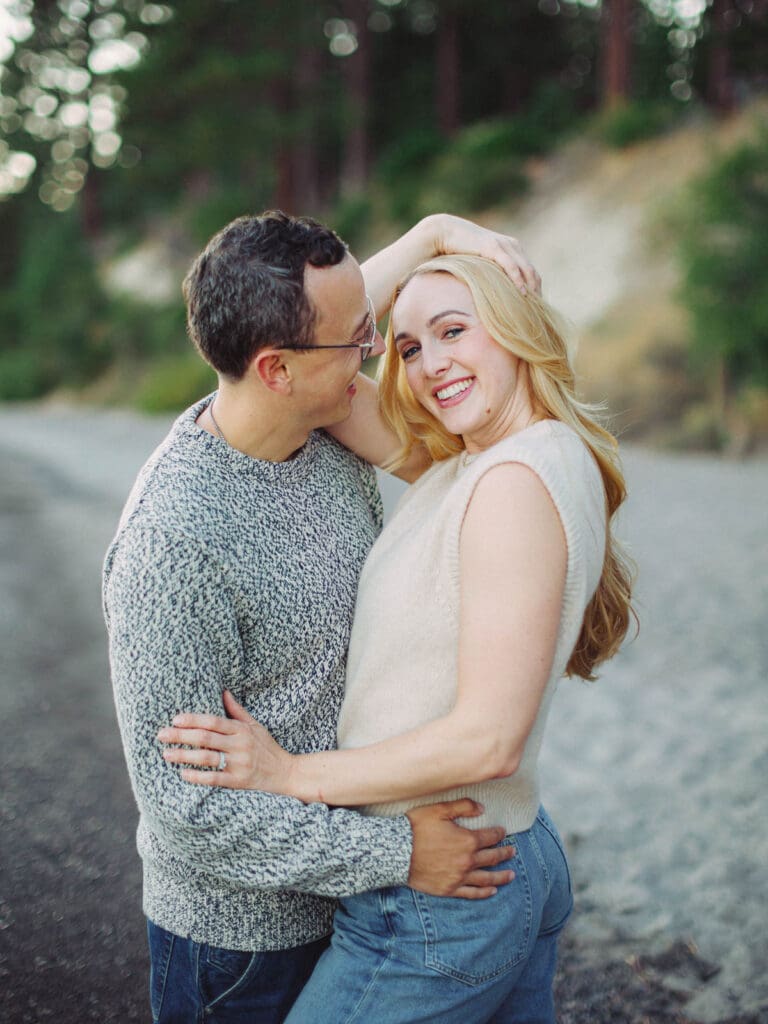 A couple embraces on the beach during a family photo session at Lake Tahoe, capturing a moment of love and connection.