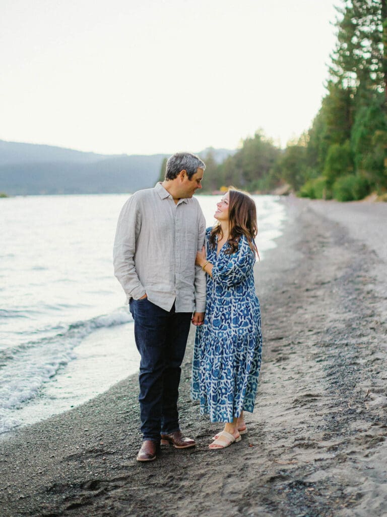 A couple embraces on the beach during a family photo session at Lake Tahoe, capturing a moment of love and connection.