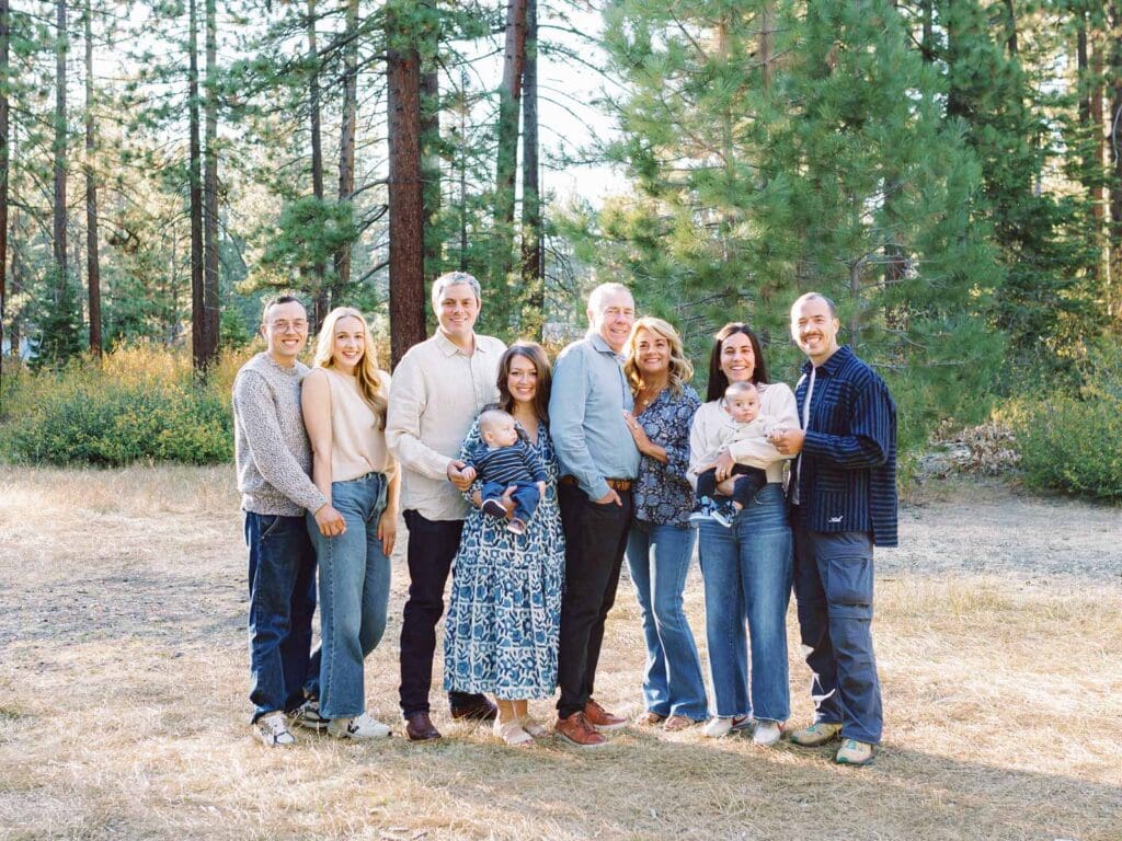 A cheerful family standing posing in the Lake Tahoe meadows, enjoying a picturesque day.