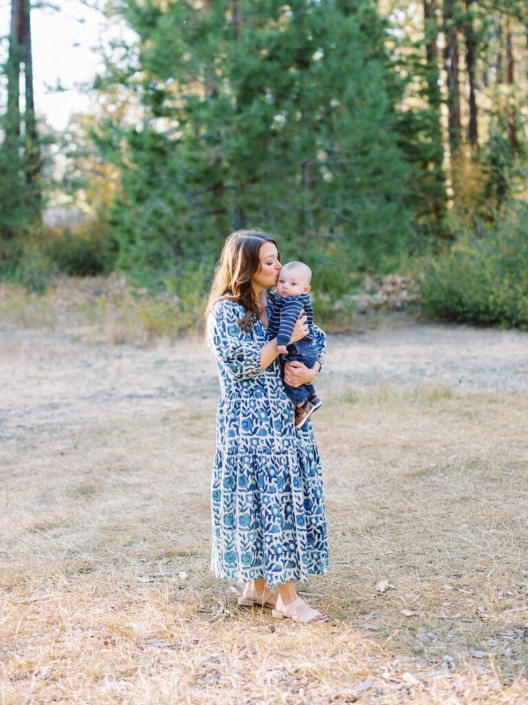 Mother and son poses together in a lush field surrounded by trees during their Lake Tahoe photo session.