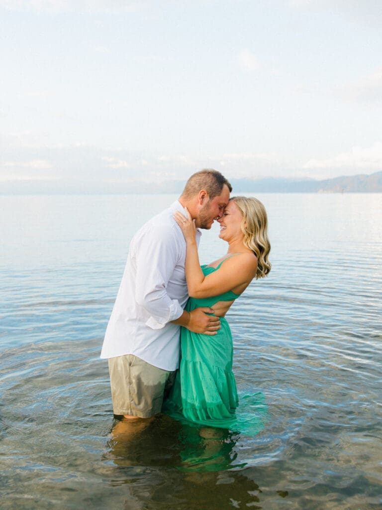 Romantic engagement photos at Lake Tahoe, featuring a stunning sunset and majestic mountains.