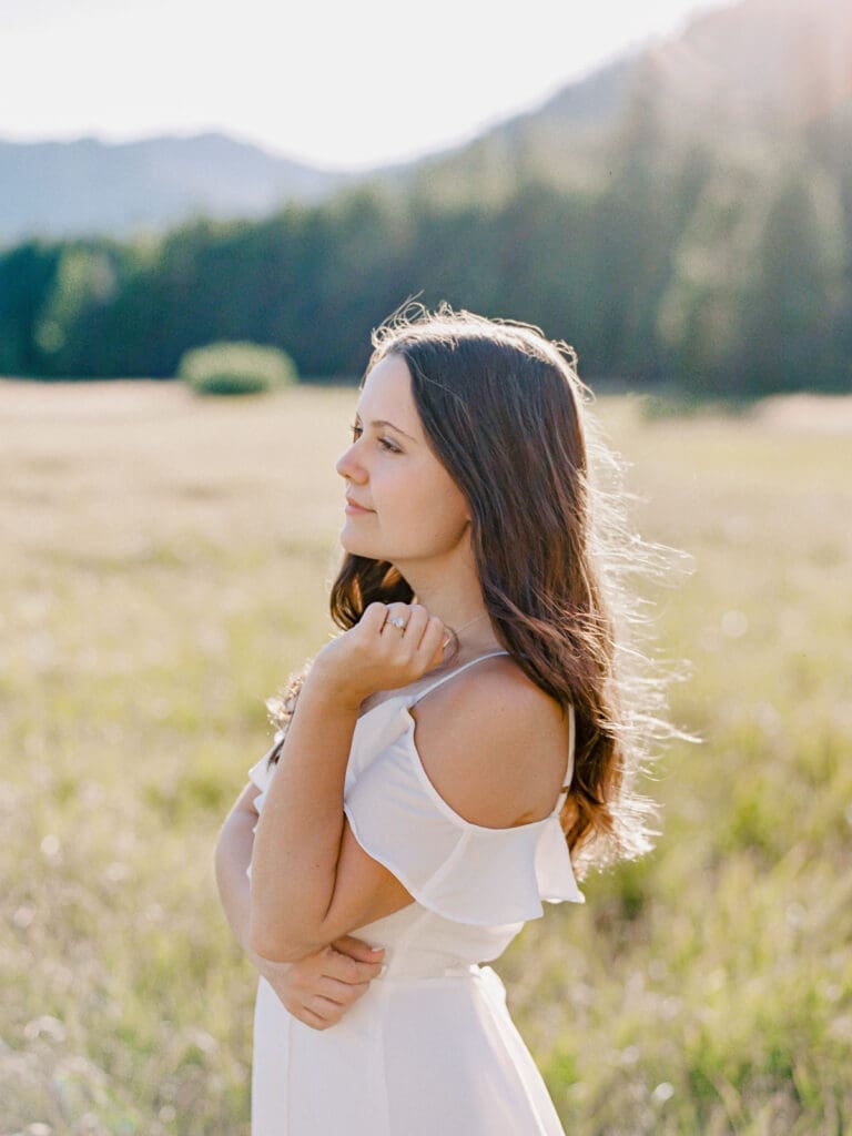 Engaged couple stands in a picturesque field, capturing a romantic moment during their Lake Tahoe engagement photo session.