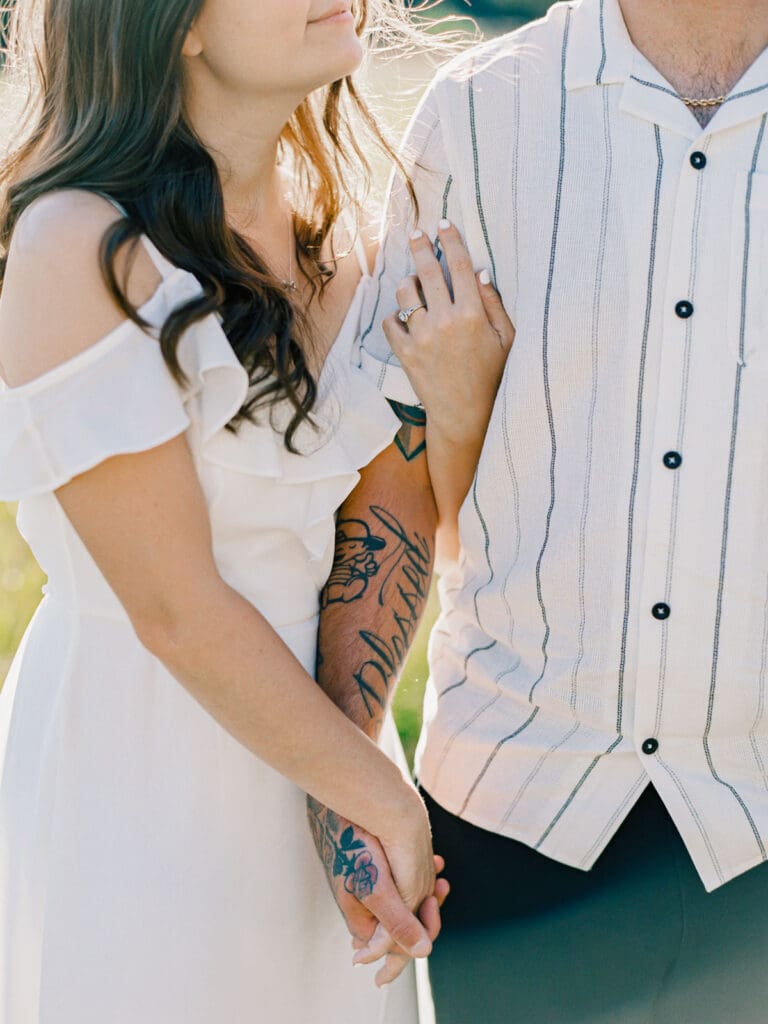 Engaged couple stands in a picturesque field, capturing a romantic moment during their Lake Tahoe engagement photo session.