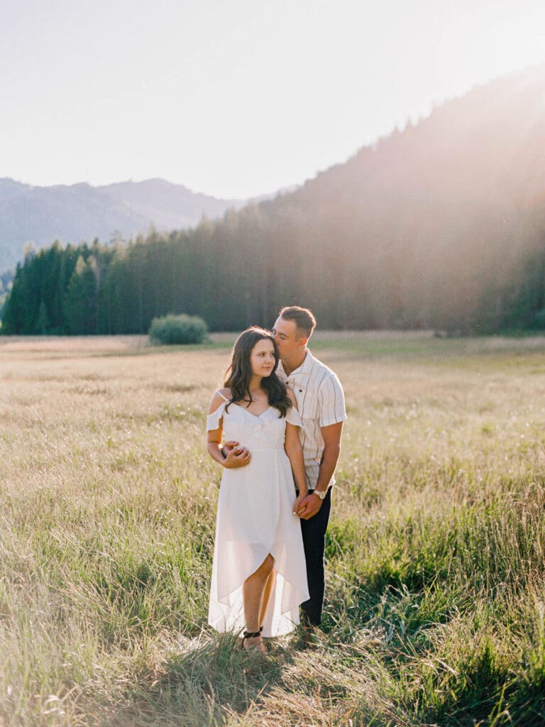 Engaged couple stands in a picturesque field, capturing a romantic moment during their Lake Tahoe engagement photo session.