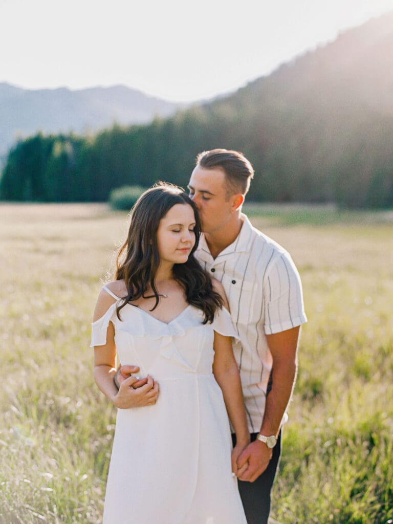 Engaged couple stands in a picturesque field, capturing a romantic moment during their Lake Tahoe engagement photo session.