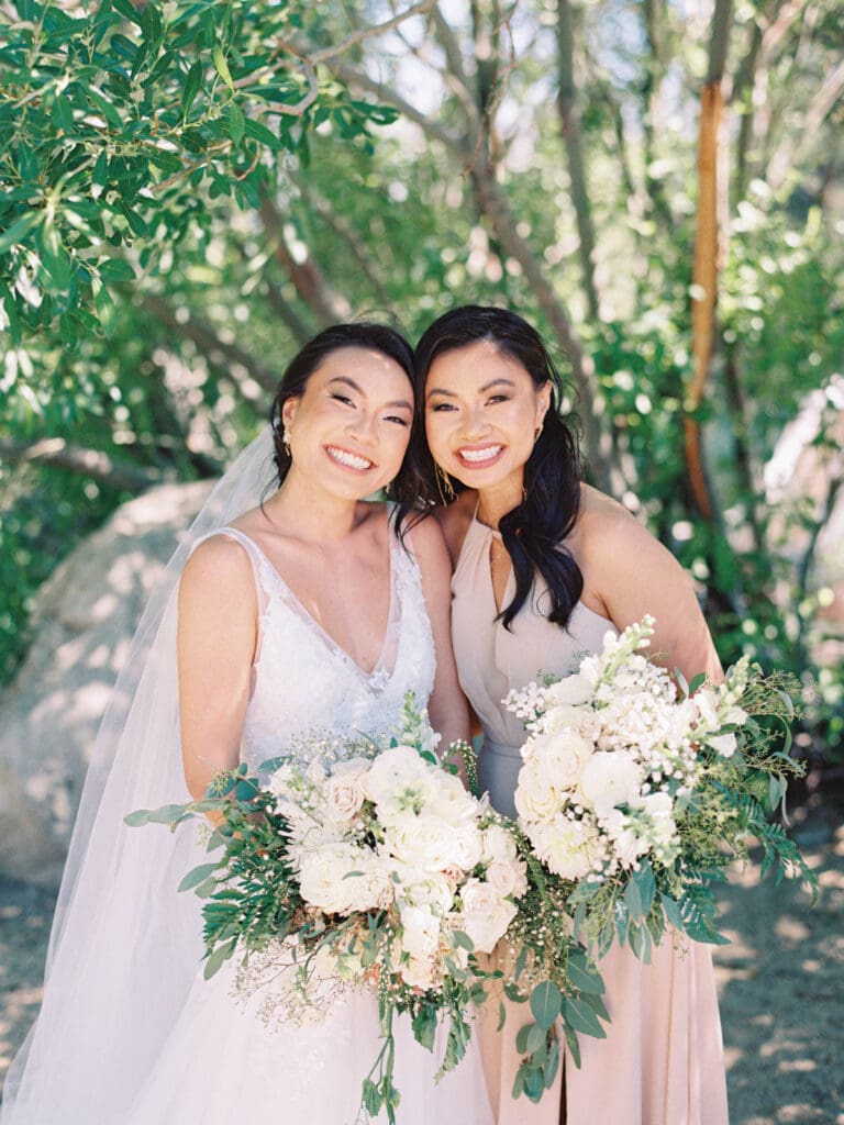 Bride and Bridesmaid pose for a wedding photo captured by the photographer.