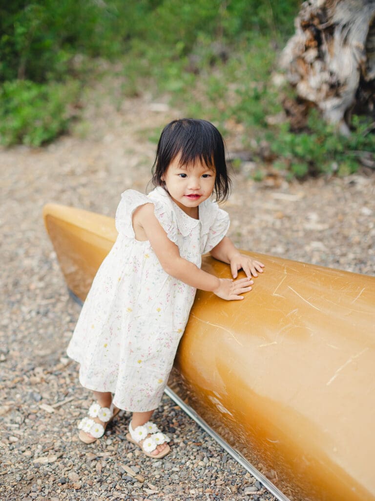 A little girl in a dress poses on a boat, captured during a family photography session in South Lake Tahoe.