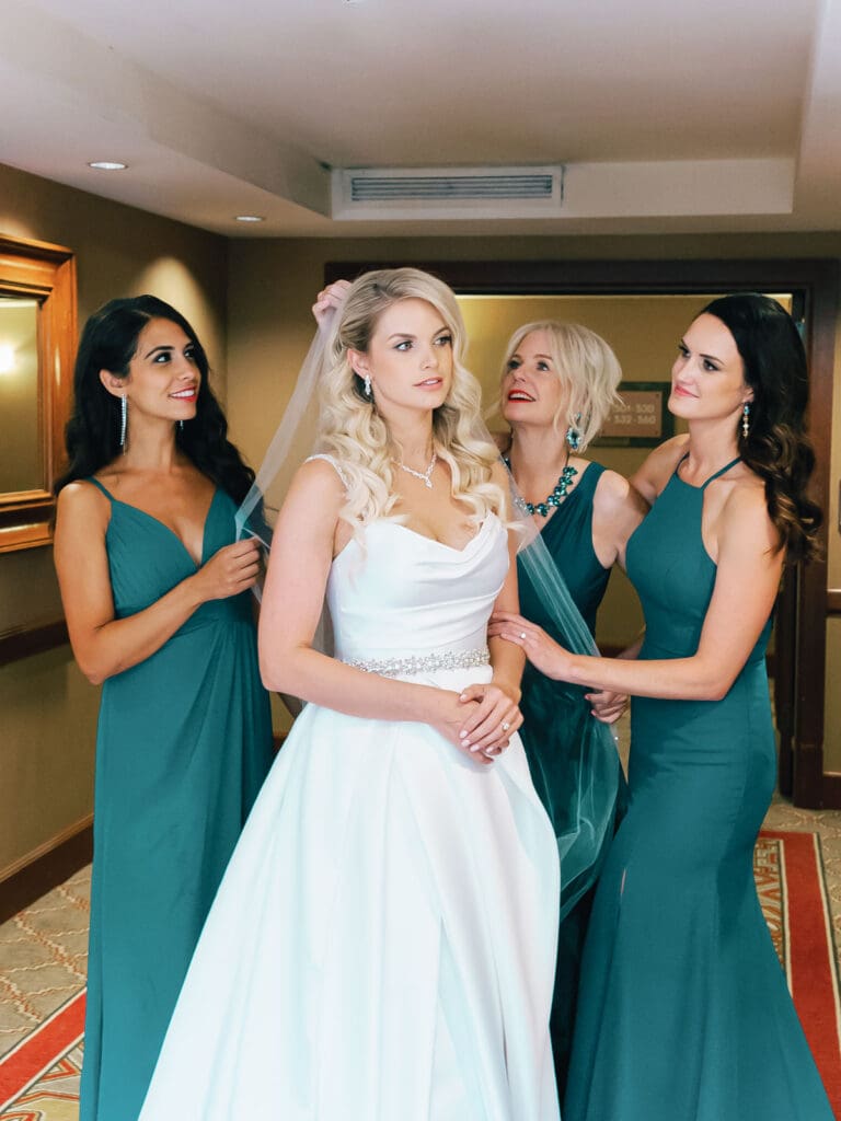 Bride and bridesmaids in teal dresses pose together during getting ready portraits at Everline Resort, Lake Tahoe.