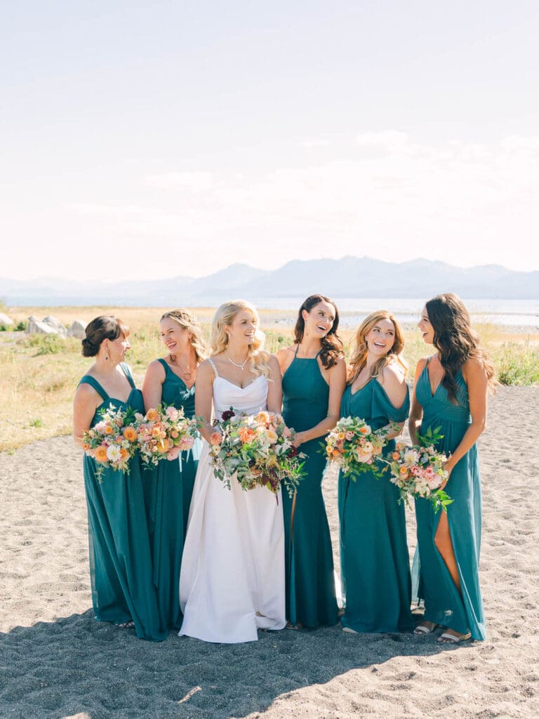 A picturesque bridesmaids in teal dresses at Everline Resort, showcasing the beautiful First Look with Lake Tahoe in the background.