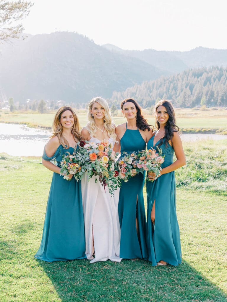 A stunning bride and her bridesmaids in teal captured by Lake Tahoe wedding photographer at Everline Resort, set against the beautiful Lake Tahoe mountains.