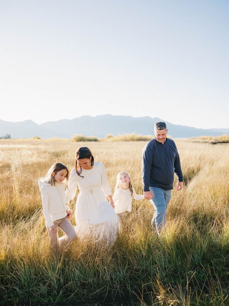 A family walking together in a scenic field during their photo session in , capturing joyful moments.