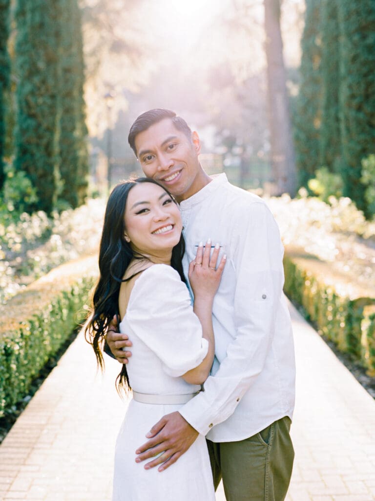 Couple smiling and embracing at romantic Villa Montalvo engagement session in San Francisco, showcasing a couple's love amidst stunning landscapes.