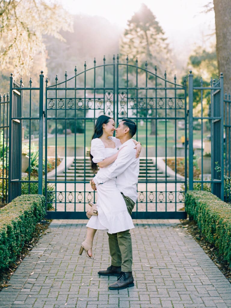 A couple celebrates their engagement at Villa Montalvo in San Francisco, framed by picturesque landscapes and vibrant flora.